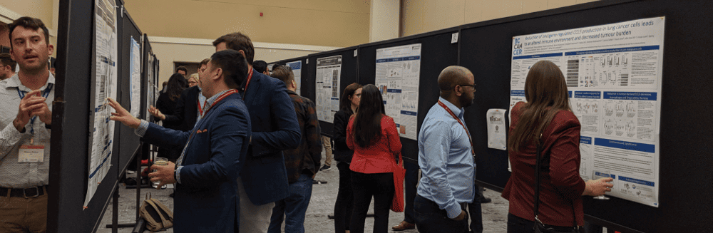 Researchers and students presenting and discussing scientific posters at a research conference, showcasing findings in cancer and cell therapy studies.